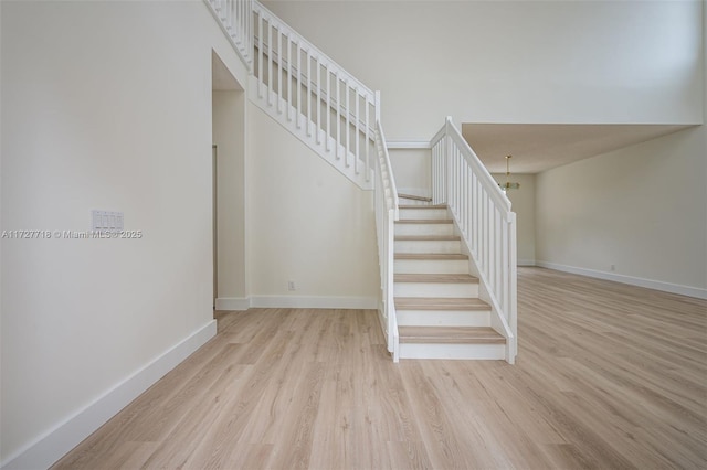 staircase with a notable chandelier and hardwood / wood-style floors