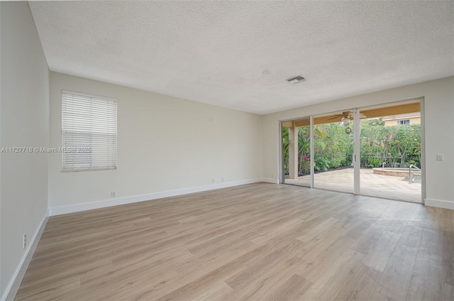 unfurnished room with a textured ceiling and light hardwood / wood-style flooring