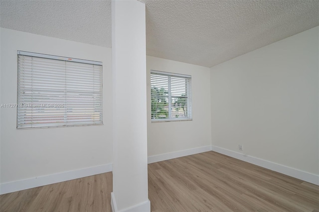 unfurnished room featuring light hardwood / wood-style floors and a textured ceiling