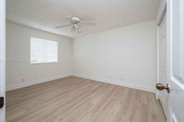 spare room with light hardwood / wood-style floors, a textured ceiling, and ceiling fan