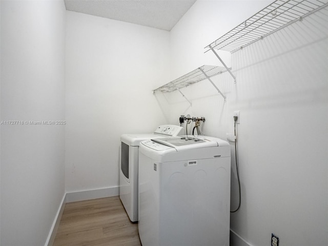 washroom featuring separate washer and dryer and light wood-type flooring