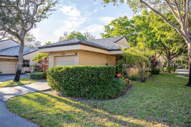 view of side of property featuring a garage and a lawn