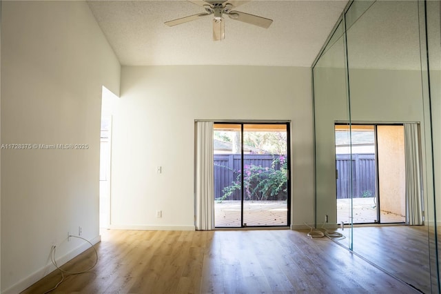 unfurnished room featuring ceiling fan, a high ceiling, a textured ceiling, and light hardwood / wood-style flooring