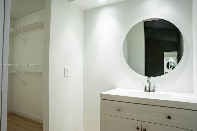 bathroom featuring washer / dryer, hardwood / wood-style flooring, and vanity