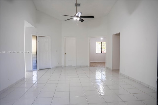 spare room featuring ceiling fan, light tile patterned flooring, and high vaulted ceiling