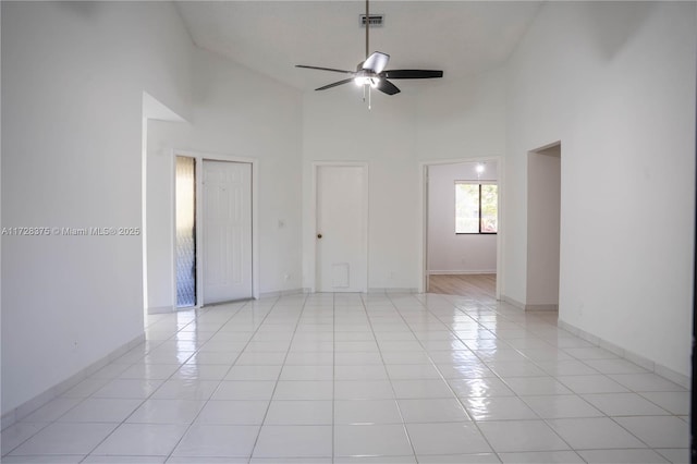 tiled spare room featuring ceiling fan and high vaulted ceiling