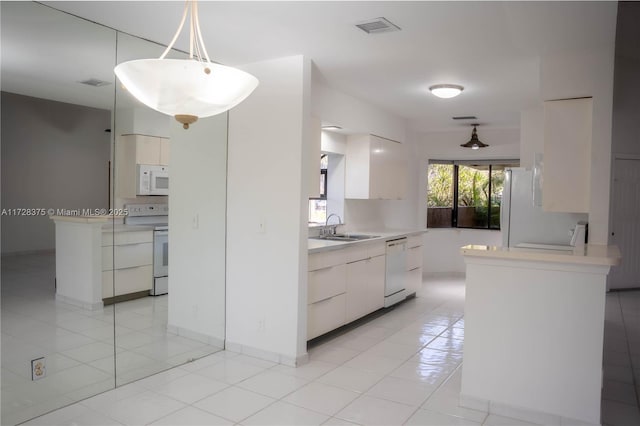 kitchen featuring light tile patterned floors, white appliances, hanging light fixtures, white cabinets, and sink