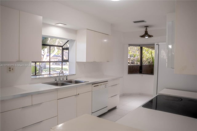 kitchen with black electric stovetop, dishwasher, pendant lighting, white cabinets, and sink