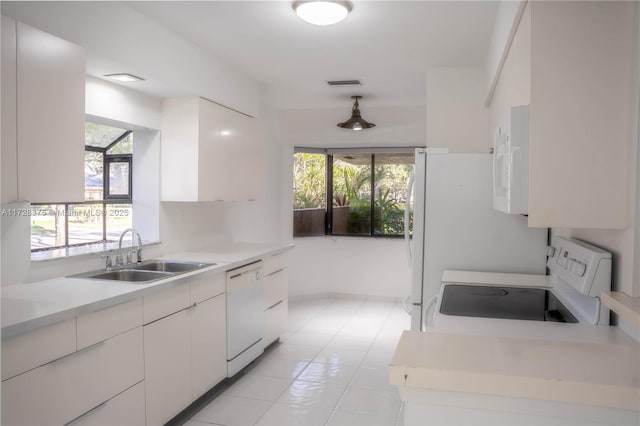 kitchen featuring light tile patterned floors, white appliances, hanging light fixtures, white cabinets, and sink