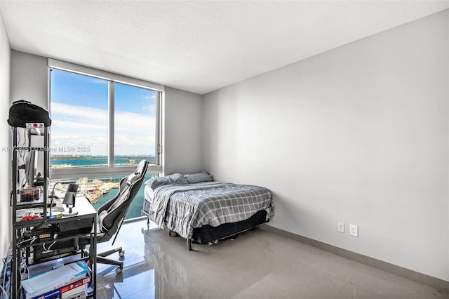 bedroom featuring a textured ceiling and a wall of windows