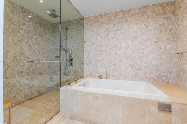 bathroom with tile walls, tile patterned floors, and separate shower and tub