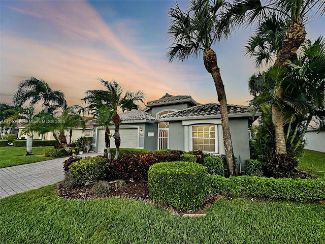 view of front of home with a garage and a yard