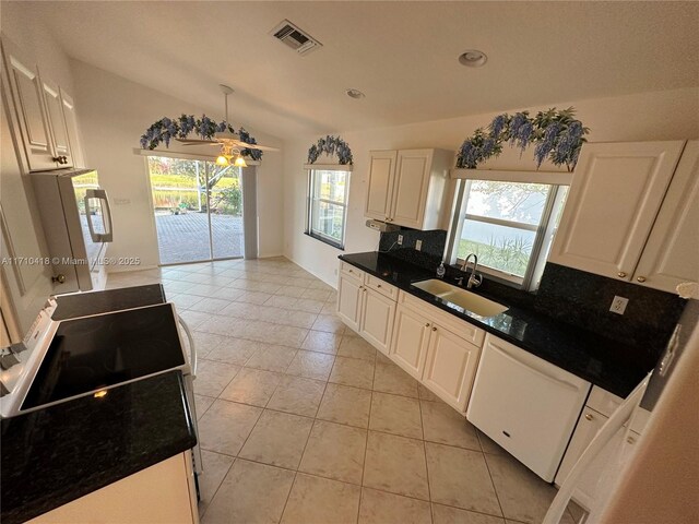 kitchen featuring lofted ceiling, white cabinetry, sink, backsplash, and white dishwasher