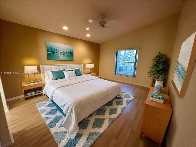 bedroom featuring ceiling fan, wood-type flooring, and vaulted ceiling