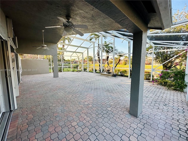 view of patio featuring ceiling fan and glass enclosure