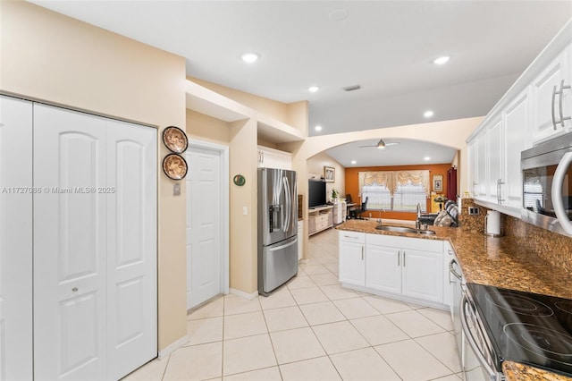 kitchen featuring ceiling fan, appliances with stainless steel finishes, dark stone countertops, and white cabinets