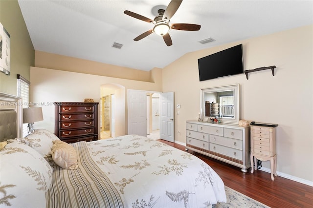 bedroom featuring ceiling fan, connected bathroom, dark hardwood / wood-style floors, and lofted ceiling