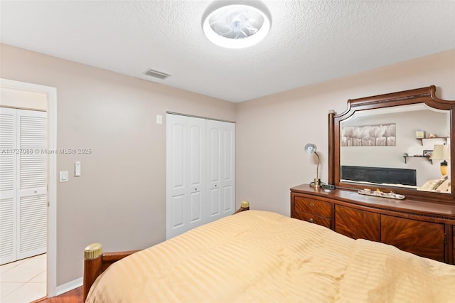 tiled bedroom with a textured ceiling