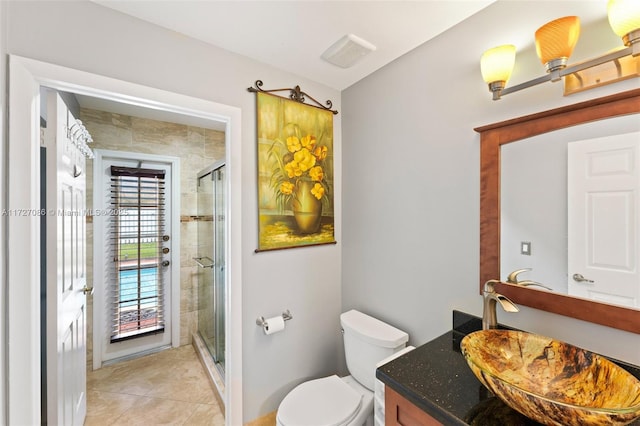 bathroom featuring walk in shower, vanity, tile patterned flooring, and toilet