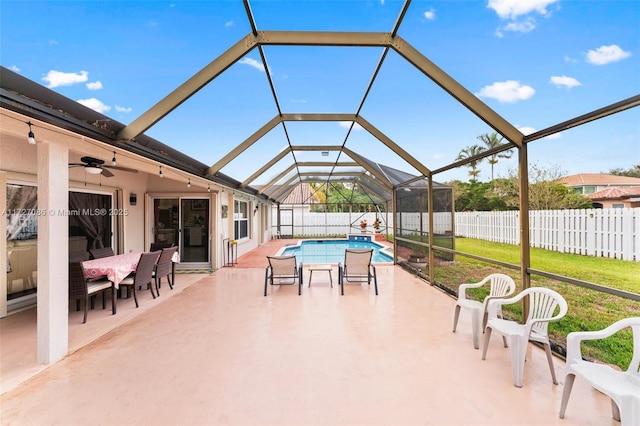 view of patio / terrace with ceiling fan, a lanai, and a fenced in pool