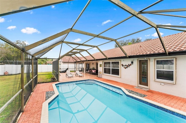 view of swimming pool featuring glass enclosure and a patio