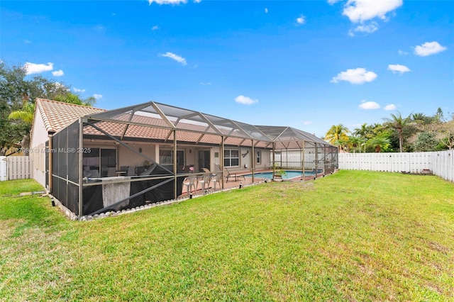 rear view of house featuring a lanai, a fenced in pool, and a yard