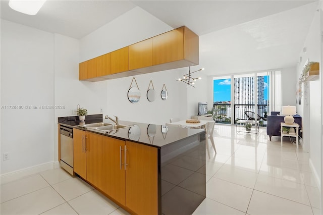 kitchen featuring expansive windows, dishwasher, sink, and light tile patterned floors