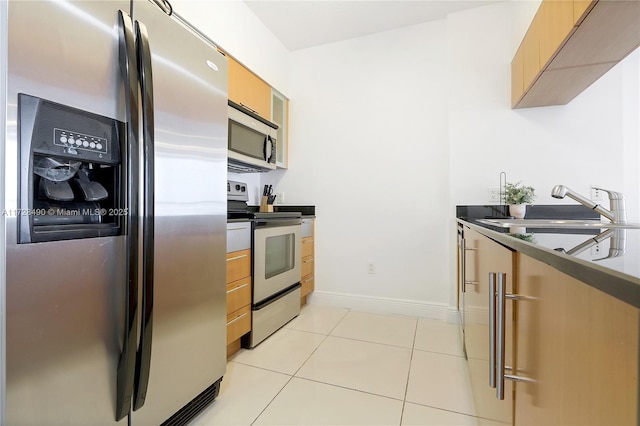 kitchen featuring light tile patterned flooring, stainless steel appliances, and sink