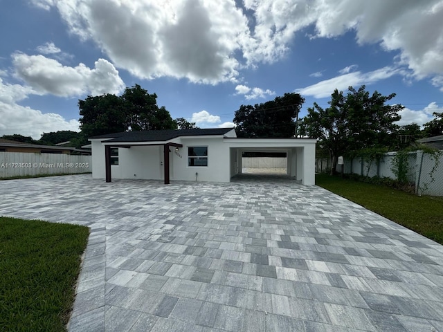 view of front of home with a carport and a front lawn