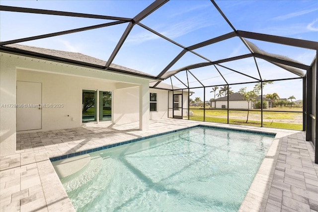 view of swimming pool with glass enclosure, a patio area, and a lawn