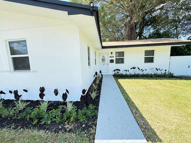 entrance to property featuring a lawn