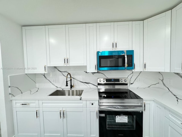 kitchen featuring white cabinetry, sink, electric range, and light stone countertops