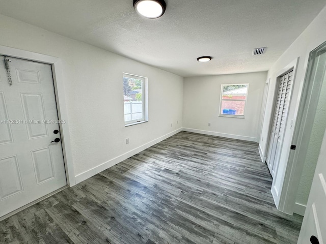 foyer with a textured ceiling and dark wood-type flooring