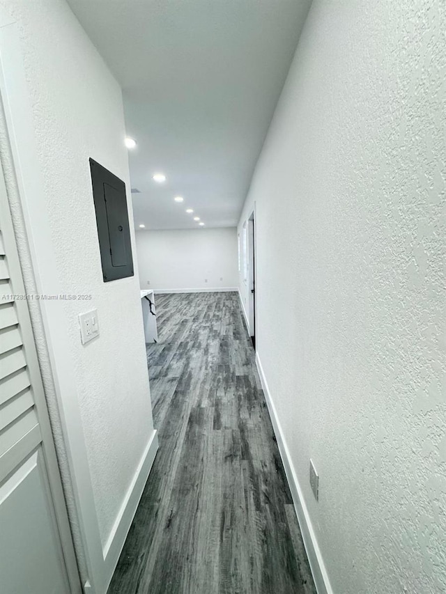 hallway with dark wood-type flooring and electric panel