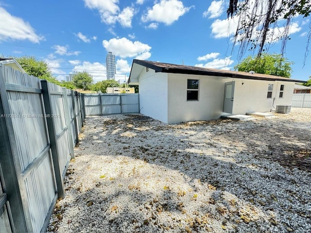 rear view of property with central AC