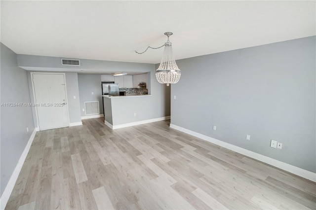 interior space featuring light hardwood / wood-style floors and an inviting chandelier