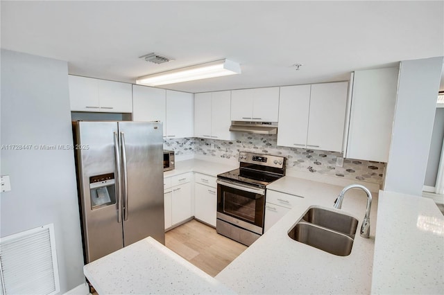 kitchen with stainless steel appliances, white cabinets, tasteful backsplash, and sink