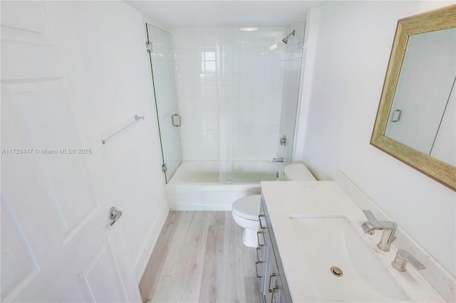 full bathroom with toilet, bath / shower combo with glass door, vanity, and hardwood / wood-style floors