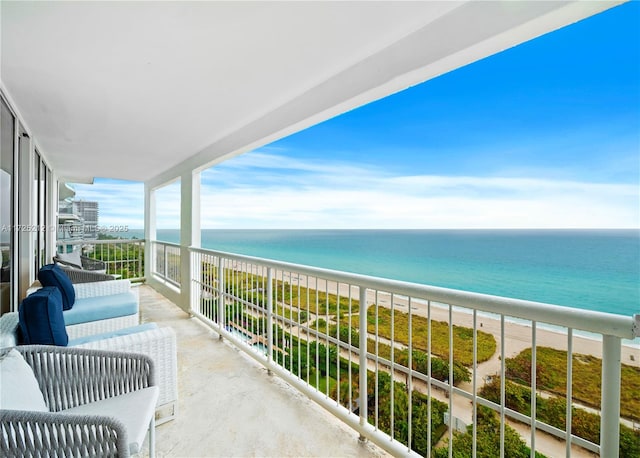 balcony with a water view and a view of the beach