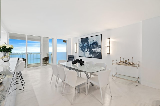 dining space featuring a water view and floor to ceiling windows