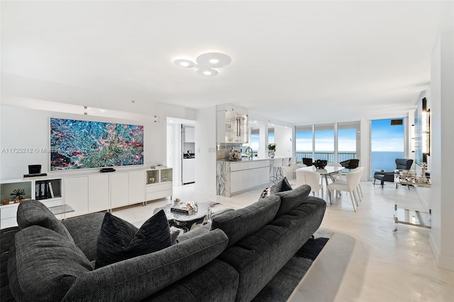 living room featuring sink, expansive windows, and a water view