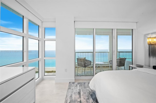 bedroom featuring a water view, multiple windows, and a beach view