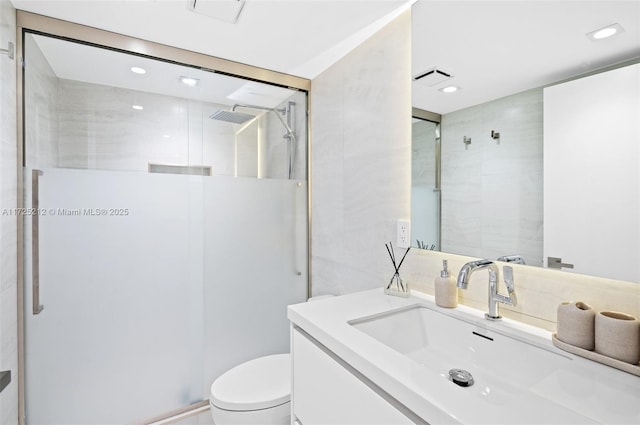 bathroom with toilet, a shower with shower door, and vanity