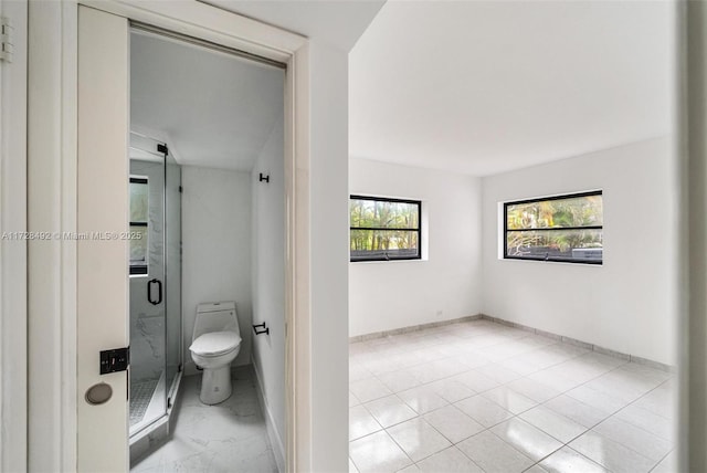 bathroom featuring toilet and an enclosed shower