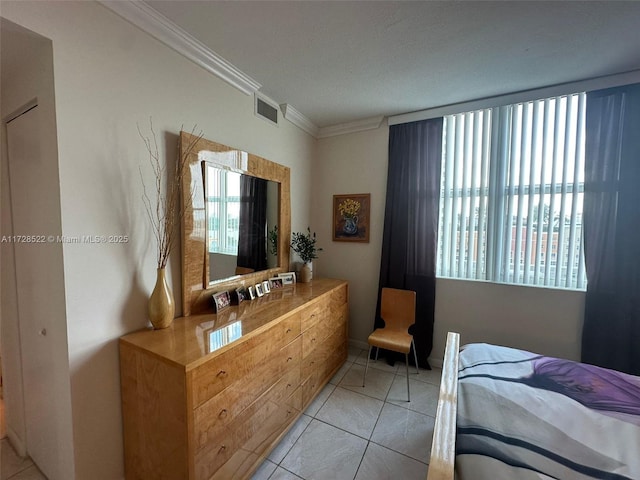 bedroom with ornamental molding and light tile patterned floors