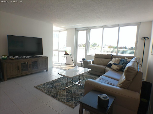 living room with floor to ceiling windows, light tile patterned floors, and a textured ceiling