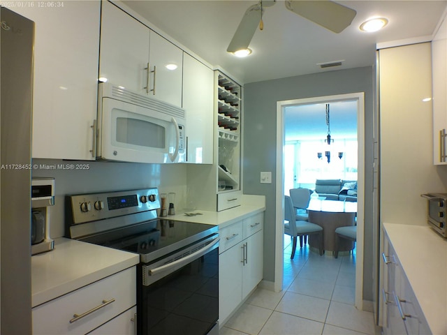 kitchen featuring white cabinetry, ceiling fan, light tile patterned flooring, and stainless steel electric range