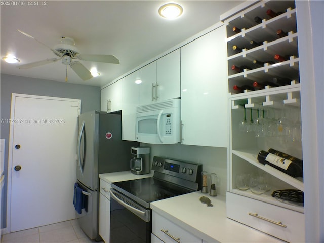 kitchen featuring white cabinetry, ceiling fan, stainless steel electric stove, and light tile patterned floors