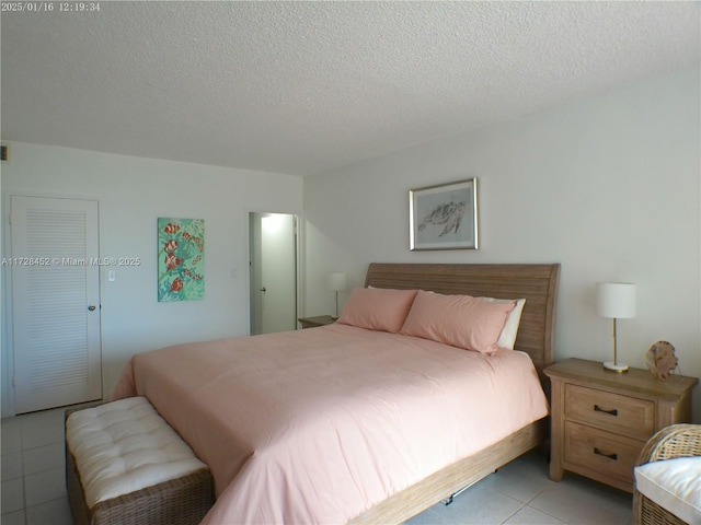 tiled bedroom featuring a textured ceiling