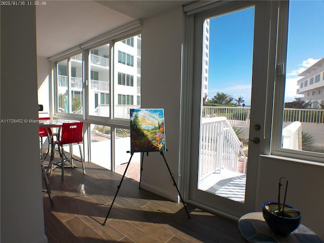 doorway to outside with dark hardwood / wood-style floors and a wealth of natural light